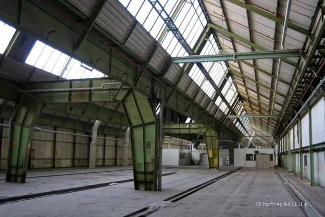 Leere Industriehalle mit Glasdach und Stahlträgern